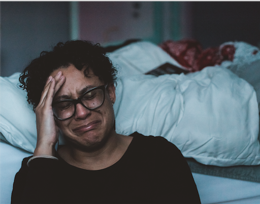 woman crying by bed